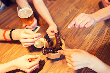 Image showing close up of hands taking garlic bread snack