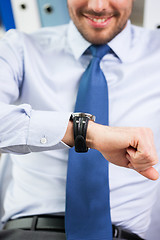 Image showing close up of businessman looking at watch in office