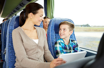 Image showing happy family with tablet pc sitting in travel bus