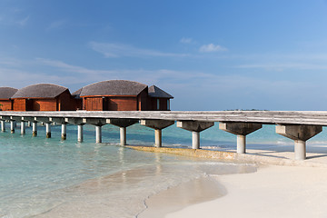 Image showing bungalow huts in sea water on exotic resort beach
