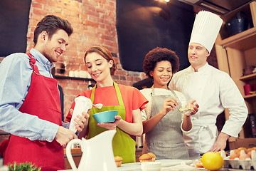 Image showing happy friends and chef cook baking in kitchen