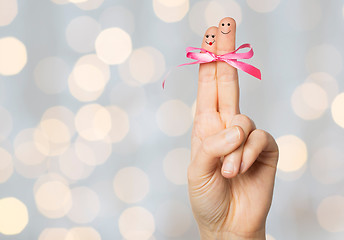 Image showing close up of two fingers tied by pink bow knot