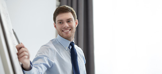 Image showing smiling businessman on presentation in office