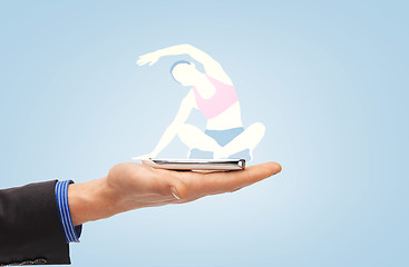 Image showing male hand with smartphone and sportswoman