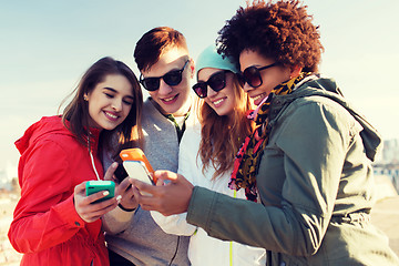 Image showing smiling friends with smartphones