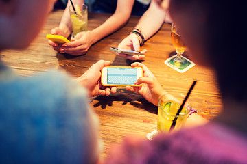 Image showing close up of hands with smartphones at restaurant