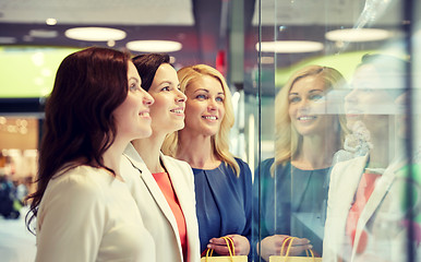 Image showing happy women looking at jewelry shop window in mall