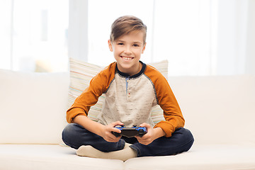 Image showing happy boy with joystick playing video game at home