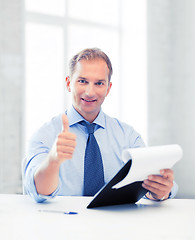 Image showing businessman with papers showing thumbs up