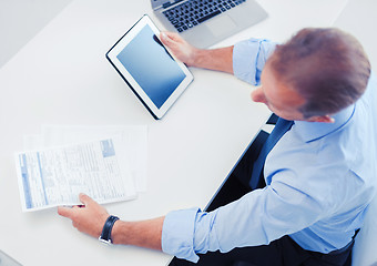 Image showing businessman with tablet pc and papers in office