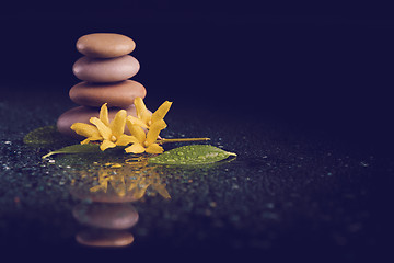 Image showing balancing zen stones on black with yellow flower