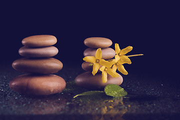 Image showing balancing zen stones on black with yellow flower