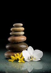 Image showing balancing zen stones on black with white flower