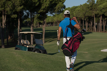 Image showing golfer  walking and carrying golf  bag