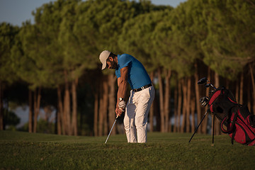 Image showing golfer hitting a sand bunker shot on sunset