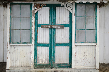 Image showing Gone fishing sign at two old doors