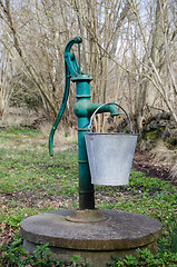 Image showing Old hand water pump with a bucket