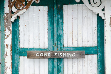 Image showing Gone fishing sign at weathered doors