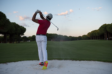 Image showing golfer hitting a sand bunker shot on sunset