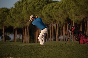 Image showing golfer hitting a sand bunker shot on sunset