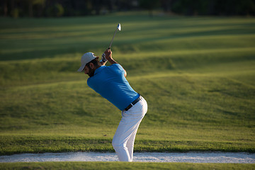 Image showing golfer hitting a sand bunker shot on sunset