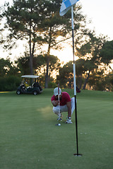 Image showing golf player aiming perfect  shot on beautiful sunset