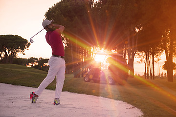 Image showing golfer hitting a sand bunker shot on sunset