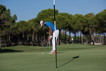 Image showing golf player hitting shot at sunny day