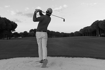 Image showing golfer hitting a sand bunker shot on sunset