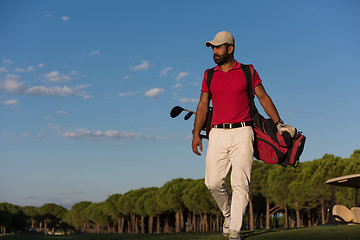 Image showing golfer  walking and carrying golf  bag