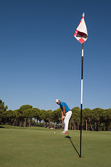 Image showing golf player hitting shot at sunny day