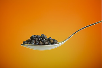 Image showing spoon filled with black peppers