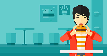 Image showing Man eating hamburger. 