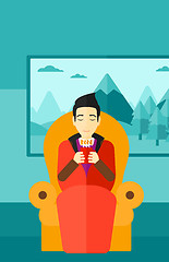 Image showing Man sitting in chair with cup of tea.