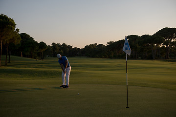 Image showing golfer hitting ball to hole