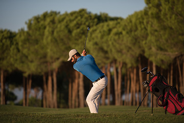 Image showing golfer hitting a sand bunker shot on sunset