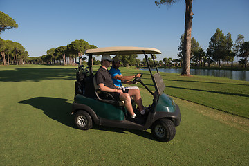 Image showing golf players driving cart at course