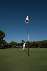 Image showing golf player hitting shot at sunny day