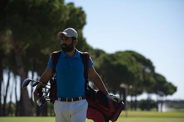 Image showing golf player walking and carrying bag