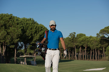 Image showing golfer  walking and carrying golf  bag