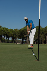 Image showing golf player hitting shot at sunny day