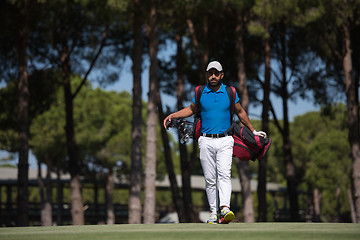 Image showing golf player walking and carrying bag