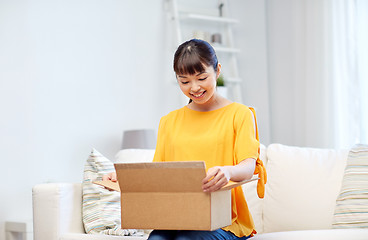 Image showing happy asian young woman with parcel box at home