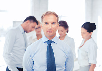 Image showing businessman in office with group on the back