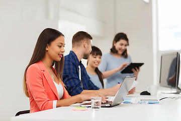 Image showing happy african woman over creative team at office