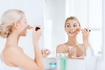 Image showing woman with makeup brush and powder at bathroom