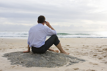 Image showing Businessman with cell phone on beach