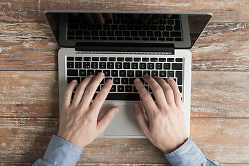 Image showing close up of male hands with laptop typing