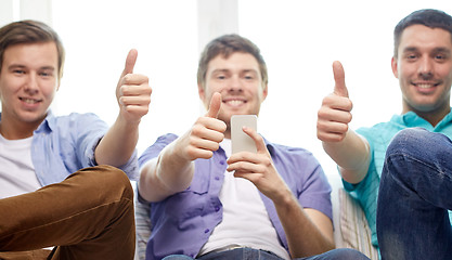 Image showing friends with smartphones showing thumbs up 