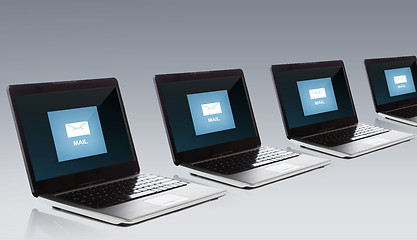 Image showing laptop computers with email message icon on screen